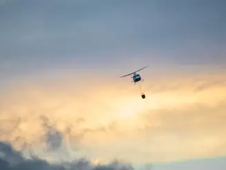 Helicopter carrying rescue basket flying in the sky